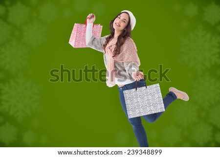 Pretty brunette posing with shopping bags against blurred snowflake design