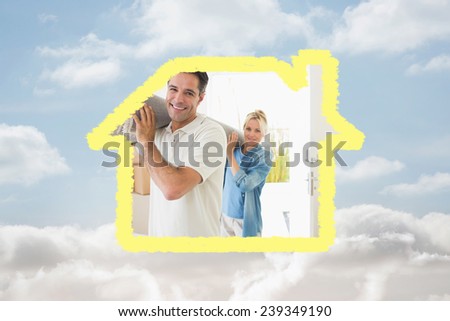 Couple carrying rolled rug after moving in a house against cloudy sky