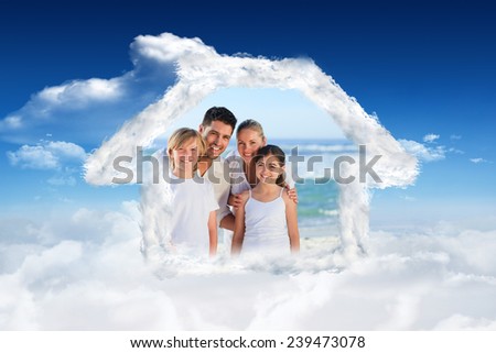 Portrait of a cute family at the beach against bright blue sky with clouds