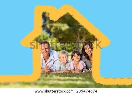 Family lying down in the park against house outline