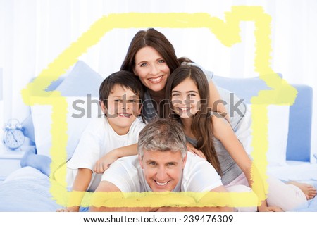 Happy family portrait in bed against house outline