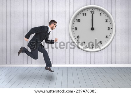 Geeky young businessman running mid air against grey room
