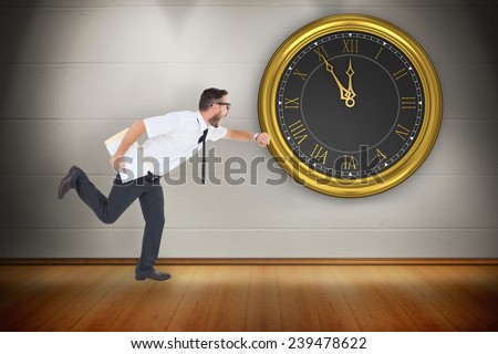 Geeky young businessman running late against room with wooden floor