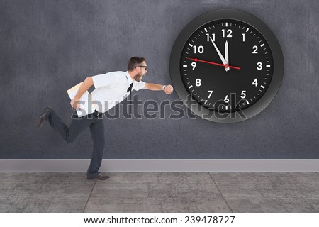 Geeky young businessman running late against grey room