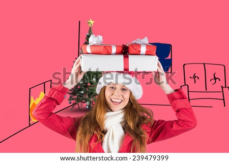 Festive redhead holding pile of gifts against pink