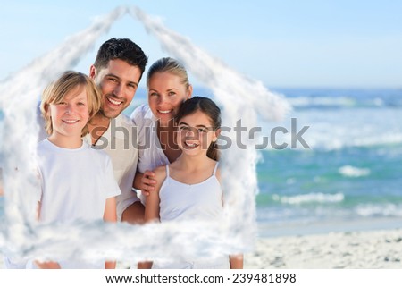 Portrait of a cute family at the beach against house outline in clouds