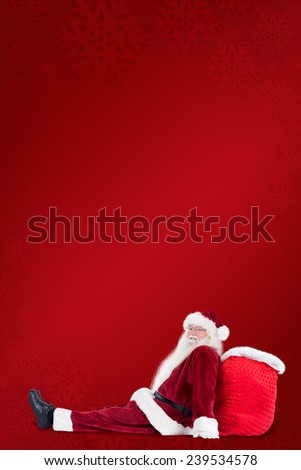 Santa sits leaned on his bag against red background