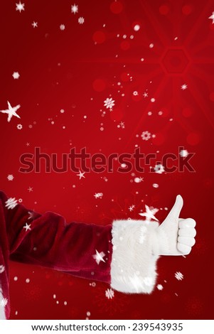 Father Christmas gives a thumb up against red snowflake background
