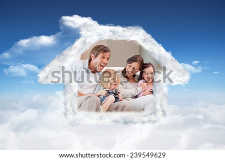 Laughing family playing video games against bright blue sky with clouds