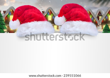 Santa hat on poster against quaint town with bright moon
