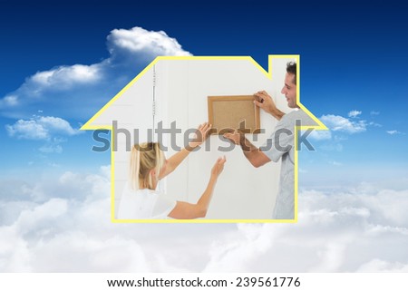 Couple decorating their new house against bright blue sky with clouds