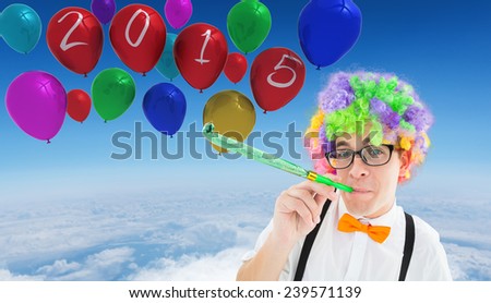 Geek blowing party horn against blue sky over white clouds