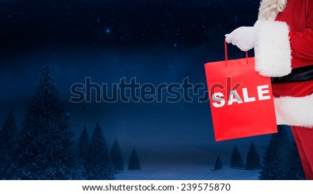Santa claus holding sale bag against night sky over forest