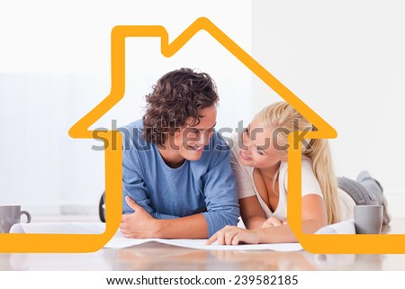 Smiling couple moving in a new house against house outline