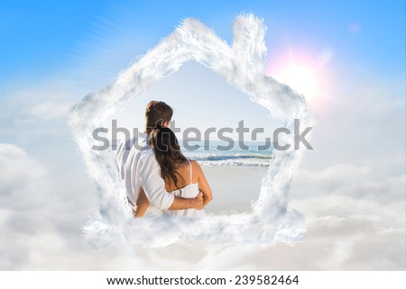 Content couple looking at the waves against blue sky with white clouds