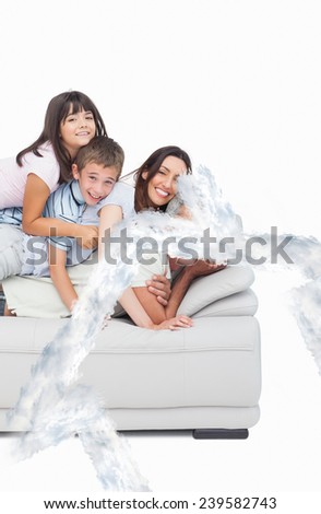 Children lying on their parents on sofa against house outline in clouds