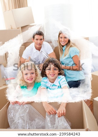Smiling family packing boxes against house outline in clouds