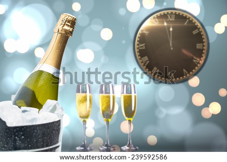Clock counting down to midnight against champagne cooling in ice bucket