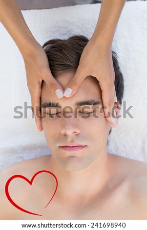 Man receiving head massage at spa center against heart