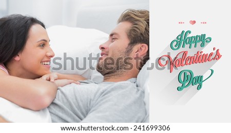 Cheerful couple awaking and looking at each other against valentines day greeting
