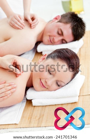 Relaxed couple receiving a back massage against linking hearts