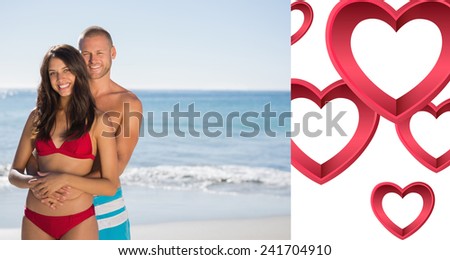 Loving couple embracing one another against pink hearts