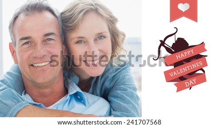 Smiling woman hugging her husband on the couch from behind against happy valentines day