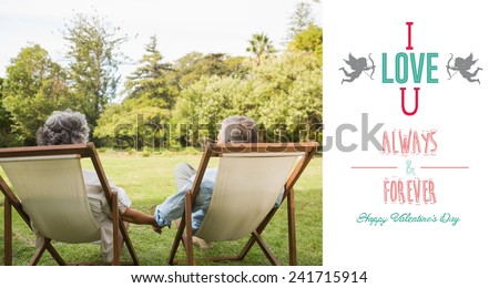 Happy mature couple sitting in park against cute valentines message