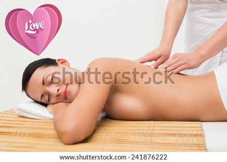 Beautiful brunette enjoying a back massage against love heart