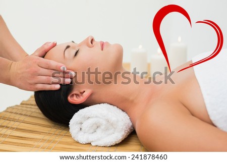 Peaceful brunette enjoying a facial massage against heart