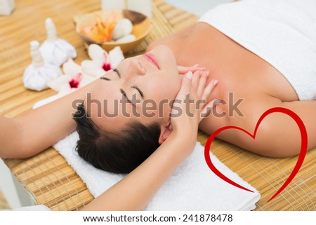 Smiling brunette enjoying a head massage against heart