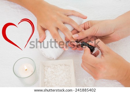 Nail technician painting customers nails against heart