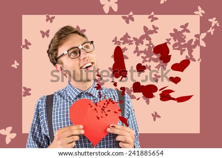 Geeky hipster holding a heart card against stencil butterfly pattern design in pink tones
