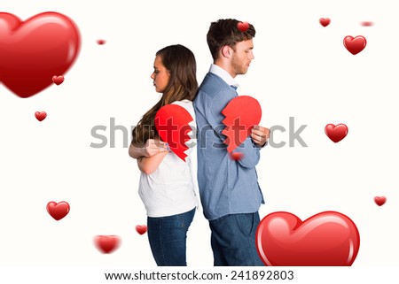 Side view of young couple holding broken heart against hearts