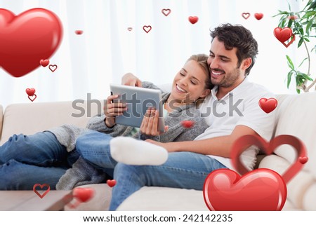 In love couple using a tablet computer against love heart pattern
