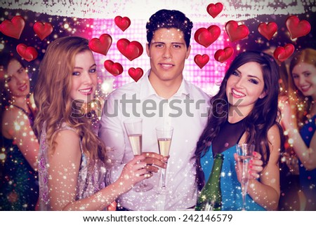 Friends drinking champagne against floating love hearts
