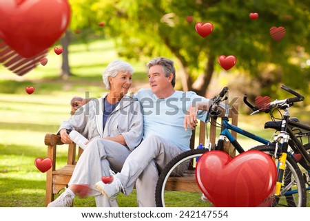Elderly couple with their bikes against love heart pattern