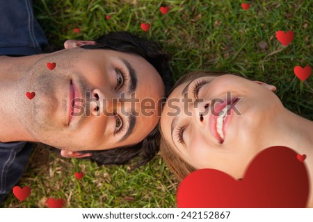 Close up of two friends looking at each other while lying head to head against hearts