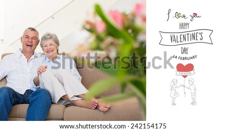 Happy senior couple relaxing on sofa against happy valentines day