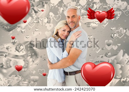 Happy couple standing and smiling at camera against grey valentines heart pattern