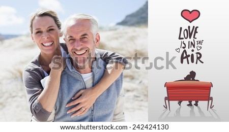 Happy hugging couple on the beach looking at camera against love is in the air