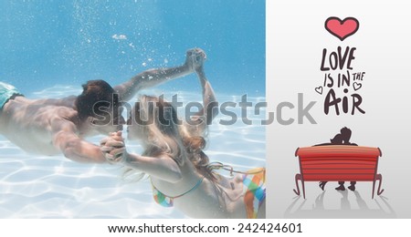 Cute couple kissing underwater in the swimming pool against love is in the air