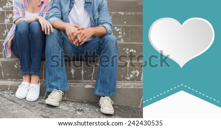 Hip young couple sitting on steps against heart label