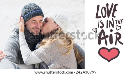 Attractive couple on the beach in warm clothing against love is in the air