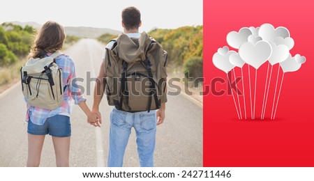 Hiking couple standing on countryside road against hearts