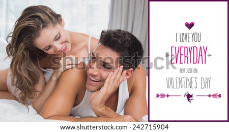 Romantic young couple in bed at home against valentines day greeting