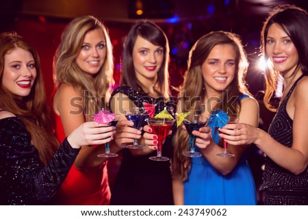 Pretty friends drinking cocktails together at the nightclub