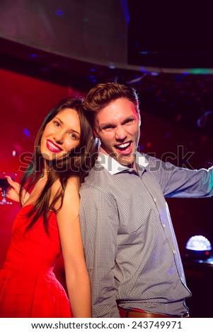Happy friends dancing and smiling at the nightclub