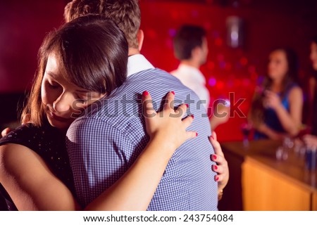 Cute couple slow dancing together at the nightclub