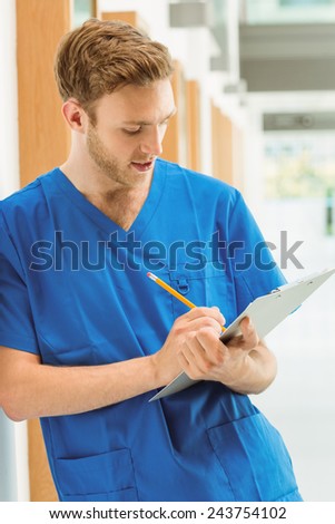 Medical student taking notes in hallway at the university